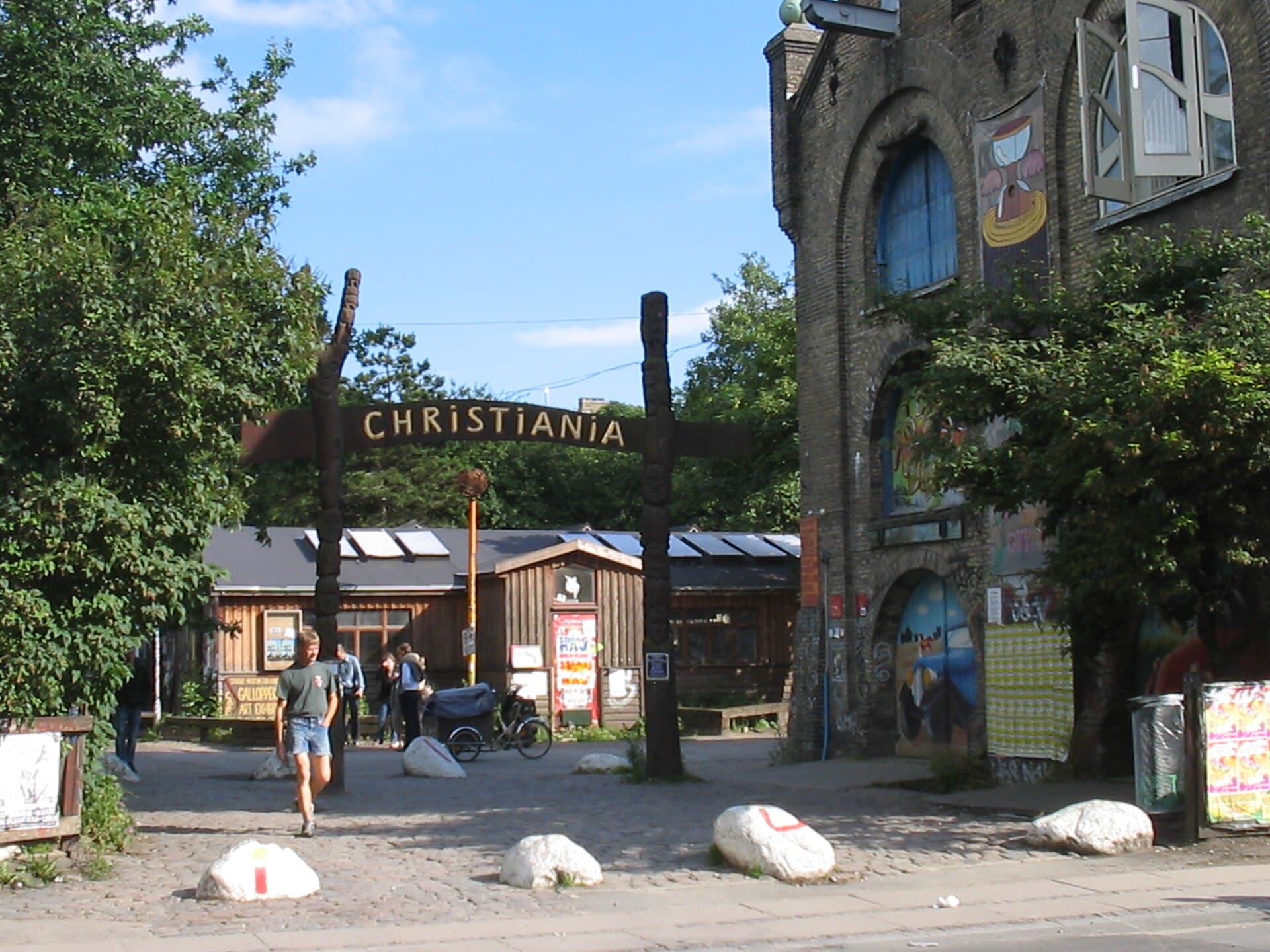 L'ingresso pedonale di Freetown Christiania, con il suo chiosco colorato e il via vai di visitatori e biciclette tipico del quartiere.