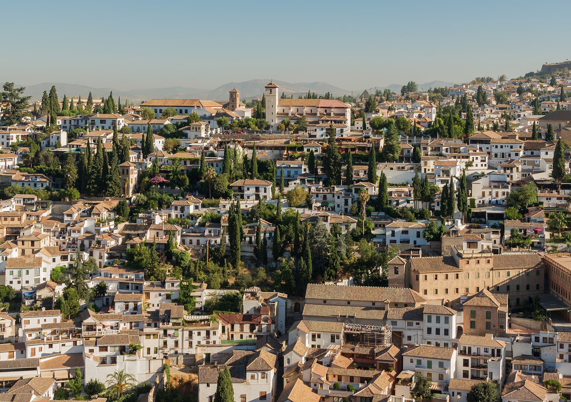 L'Albaicín visto dall'Alhambra: l'antico quartiere moresco di case bianche e carmen aggrappato alla collina, con la chiesa di San Nicolás in cima.