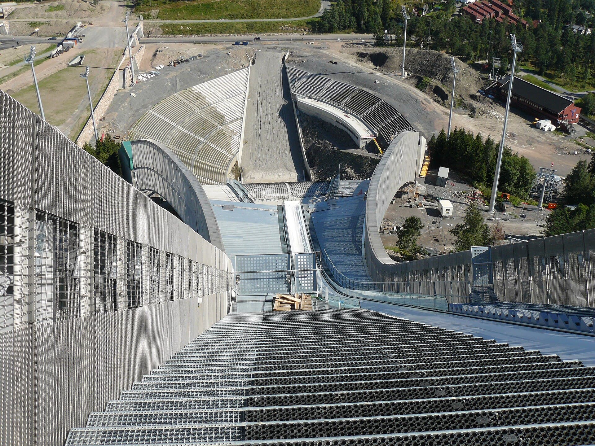 Il trampolino di Holmenkollen, a venti minuti di metro dal centro: dalla cima dell'in-run lo sguardo precipita lungo la rampa fino all'arena, con Oslo e il fiordo sullo sfondo.